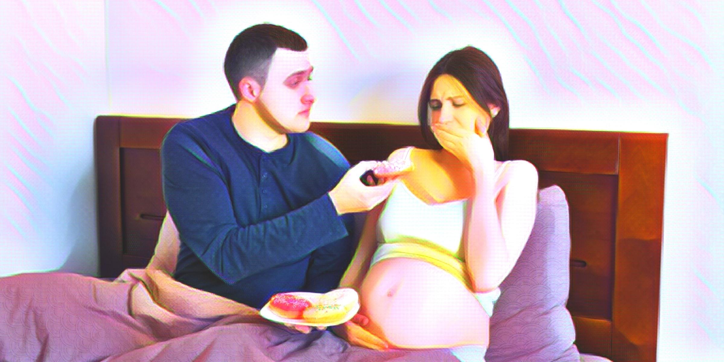 ドーナツを食べさせようとする男性と口をおさえる妊婦さん